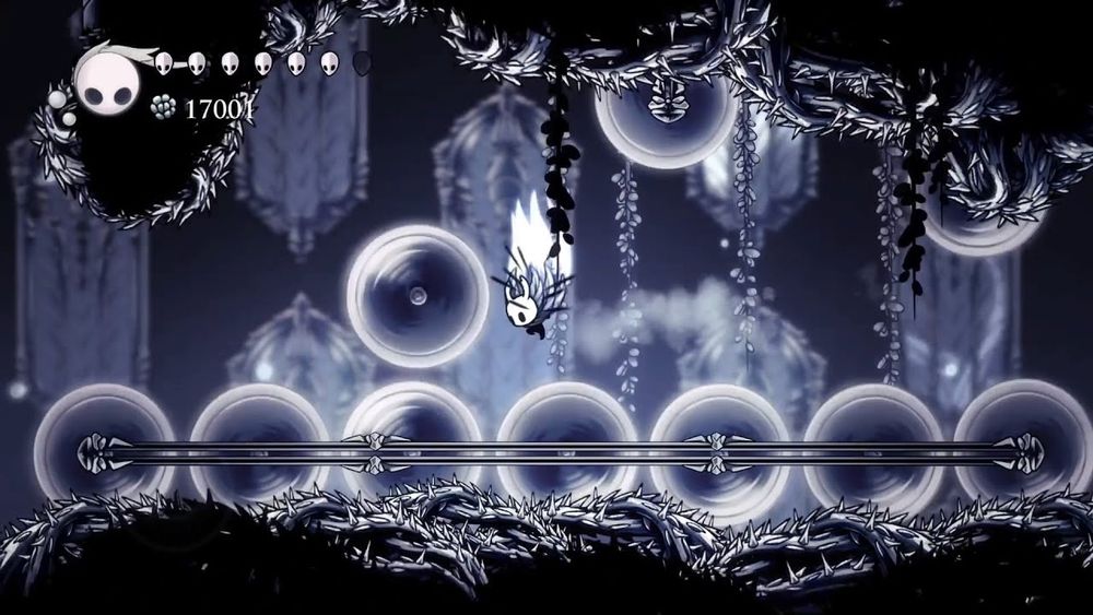 Le petit héros de Hollow Knight est entre plein de scies impossibles à éviter 
