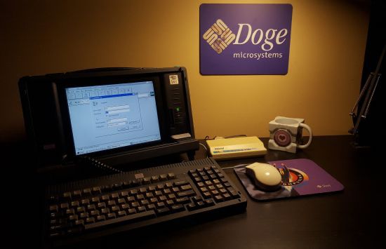 A photo of a Dolch PAC luggable PC sitting on a desk. The computer is displaying the windows 95 dialup login pane