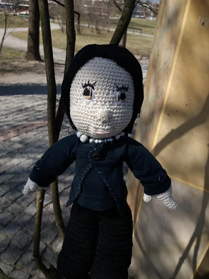Amigurumi crocheted stuffed boy in the autumn park.