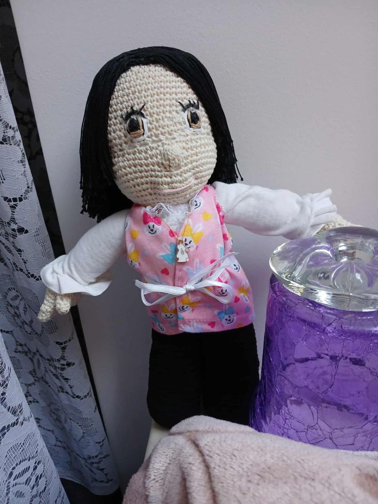 Amigurumi crocheted stuffed boy on a cosy windowsill.