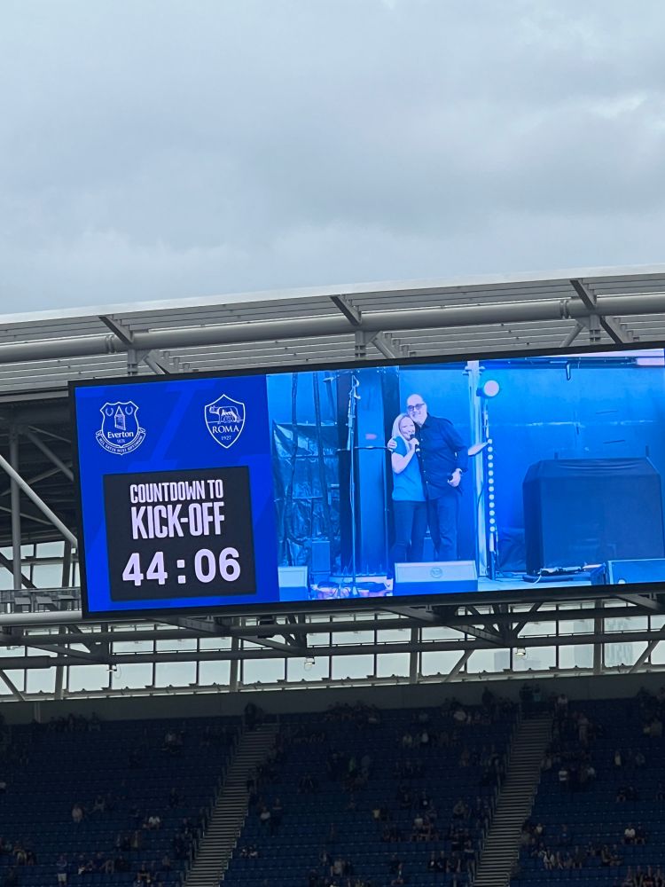 Giulia bould hugging Dan meis on the big screen in hill Dickinson stadium before the Everton versus Roma game 