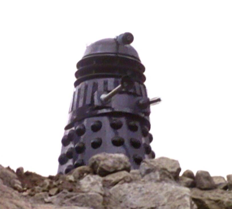 A Dalek up on a rocky ridge.
