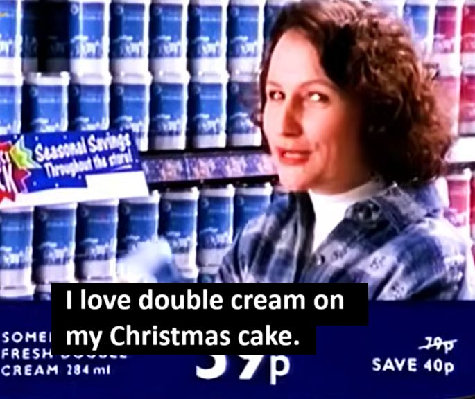Woman in Somerfield Xmas ad, standing in front of shelves of cream. She looks to camera and says "I love double cream on my Christmas cake." 
