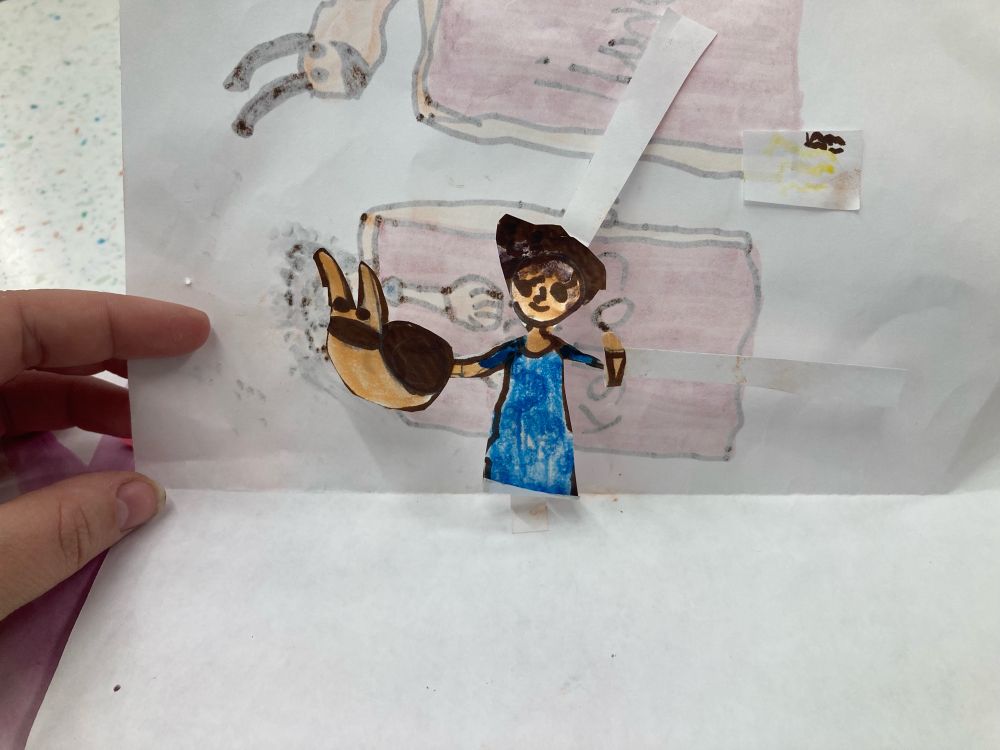 The inside of a previous childrens drawing features a pop up of a librarian and a snail puppet.