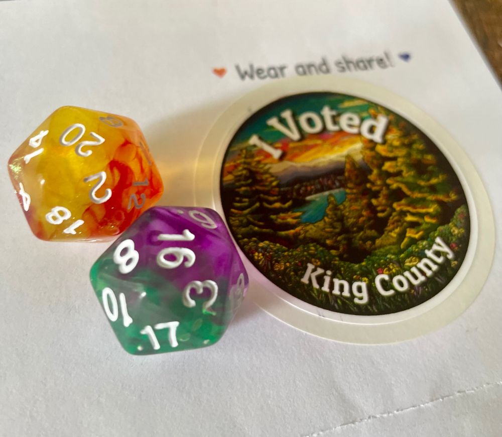 A circular “I voted King County” sticker featuring an illustration of trees next to two multicolored 20-sided dice.