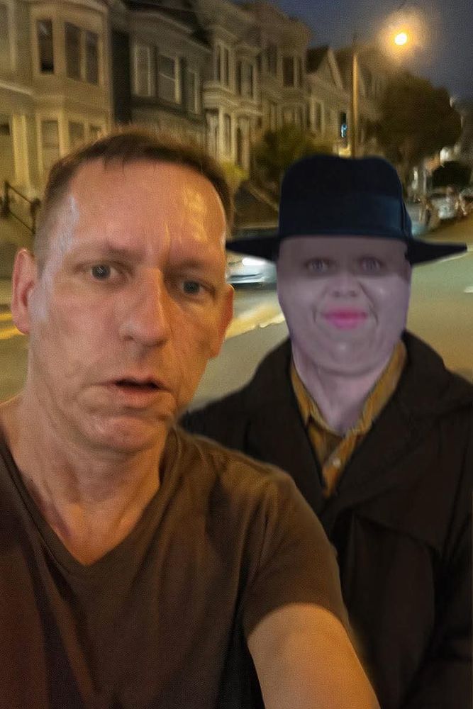 Two demons gaze at the camera from a city street at night