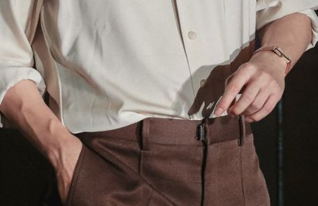 Close up of Kim Taehyung's hands. Wearing a cream colored button up and brown slacks. The veins are really what matter here.