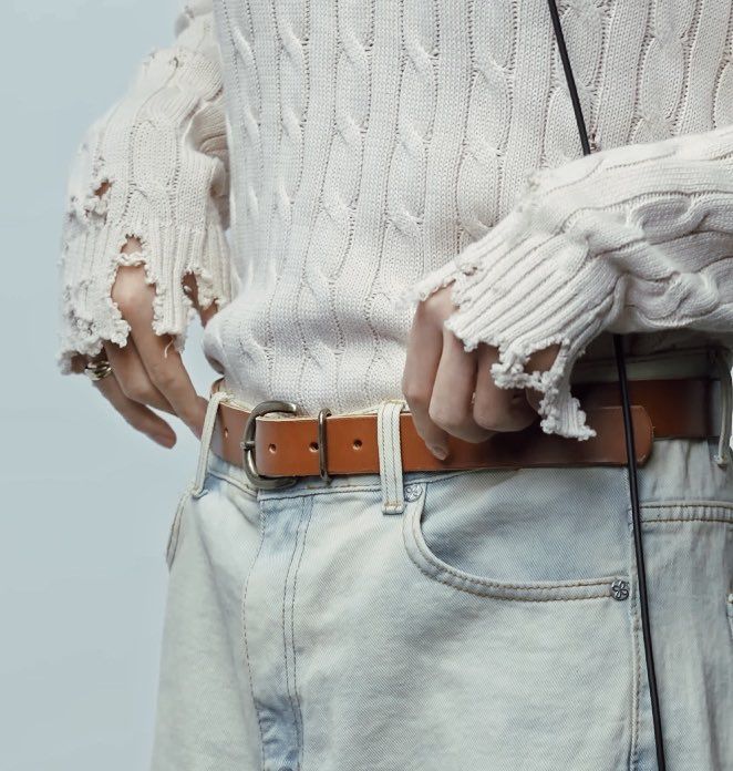 Close-up of Kim Taehyung adjusting his pants during The First Take video.