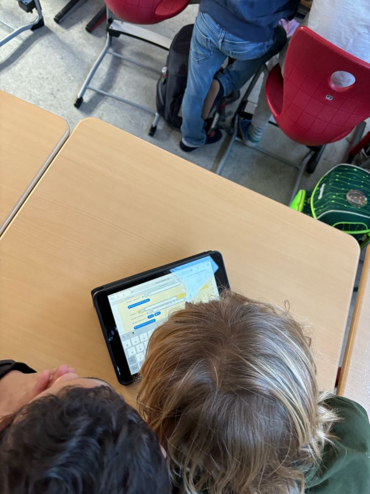Zwei Schüler Hinterköpfe beugen sich über ein Tablett, auf dem LearningApps erstellt werden.