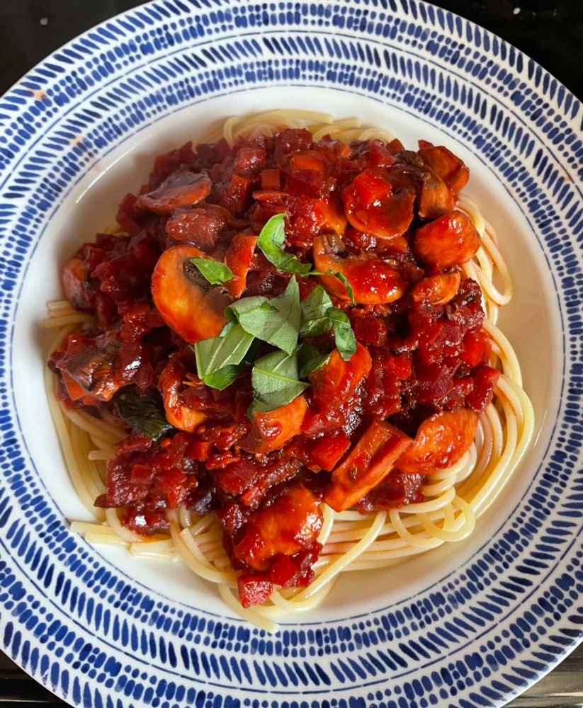 Homemade mushroom bolognese topped with torn basil.