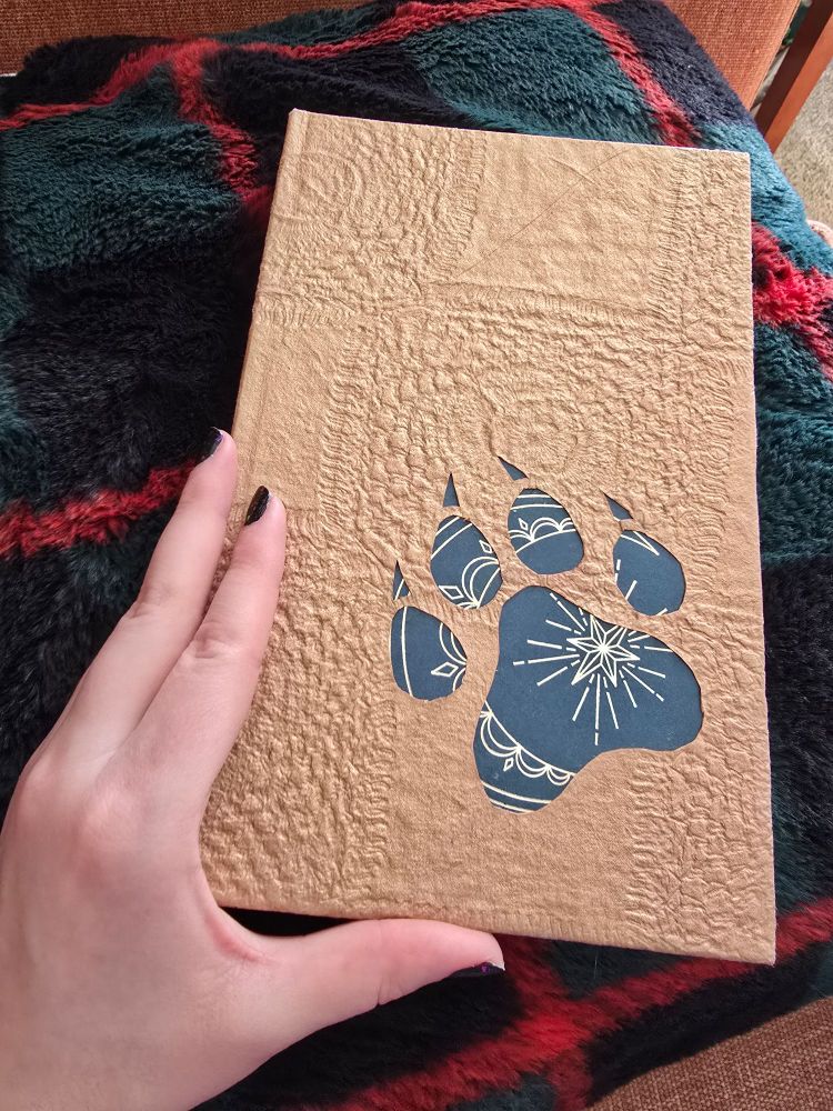 A handmade book with a wolves paw on the cover 
