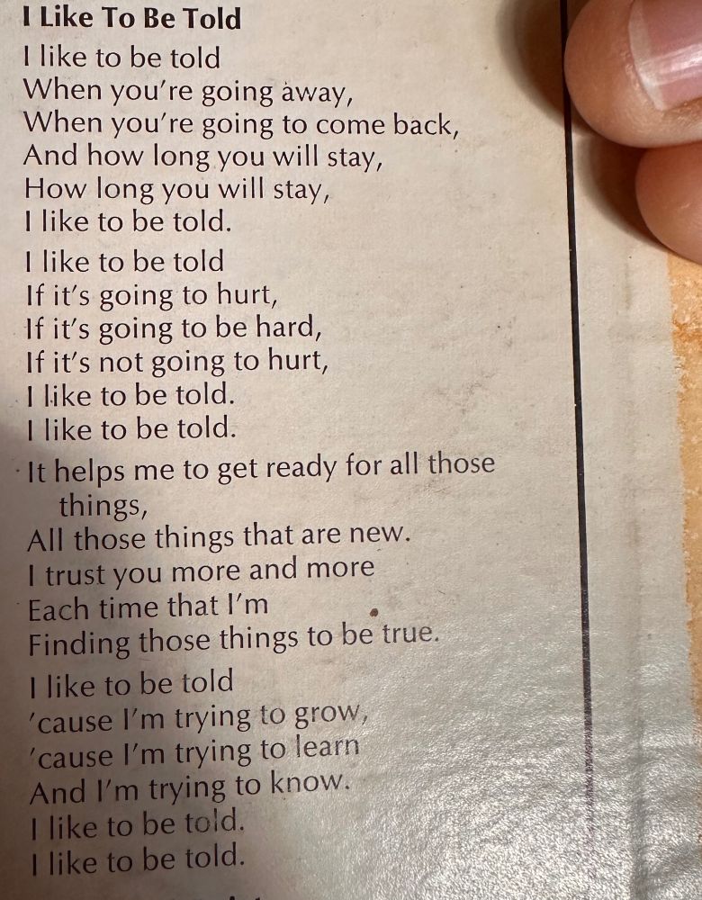 Picture of lyrics on the back of a Mr. Rogers record, with a finger visible. The words read:

I Like To Be Told 

I like to be told
When you're going away,
When you're going to come back,
 And how long you will stay, 
How long you will stay, 
I like to be told.

I like to be told
If it's going to hurt, 
If it's going to be hard, 
If it's not going to hurt, I like to be told.

I like to be told.
It helps me to get ready for all those things,
All those things that are new.
I trust you more and more
Each time that I'm
Finding those things to be true.
I like to be told
'cause I'm trying to grow,
'cause I'm trying to learn 
And I'm trying to know.
I like to be told.
I like to be told.