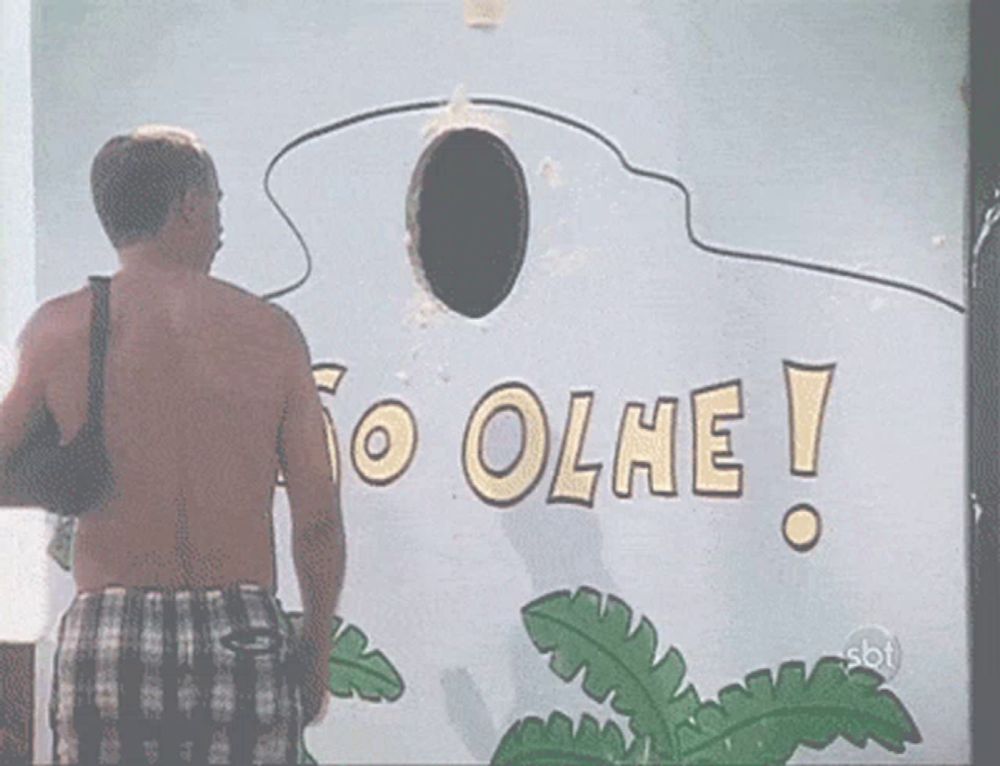 a shirtless man stands in front of a wall that says olhe on it