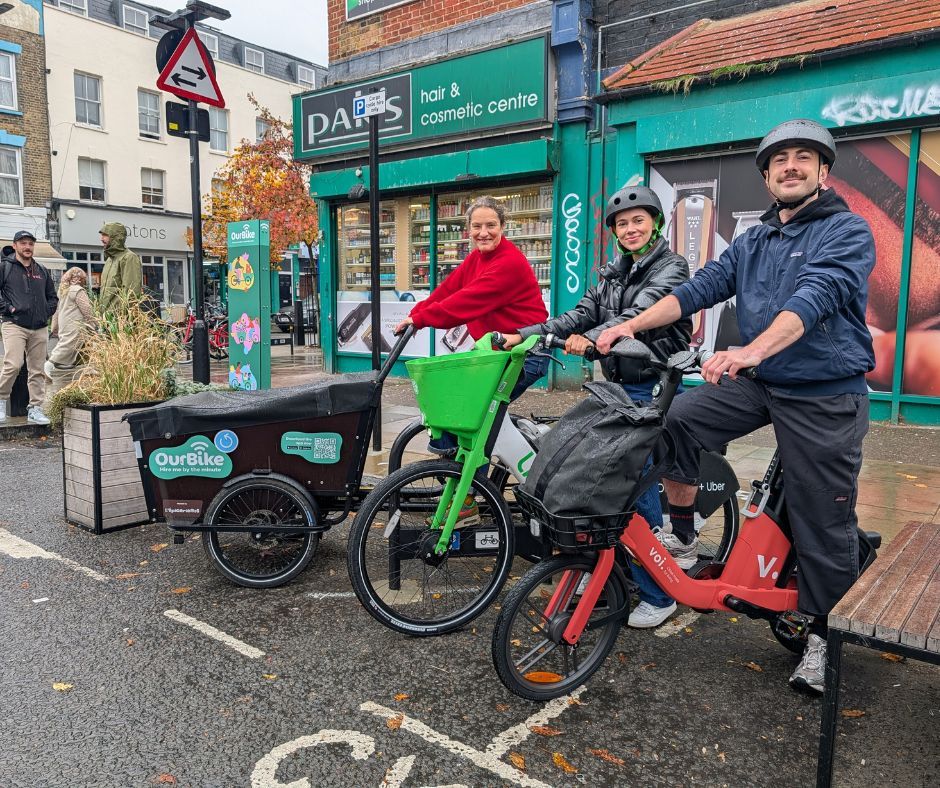 a person on a Voi bike stands next to a person on a Lime bike, next to Cllr Young, Cabinet Member for Climate Change, Environment and Transport, on a cargo bike
