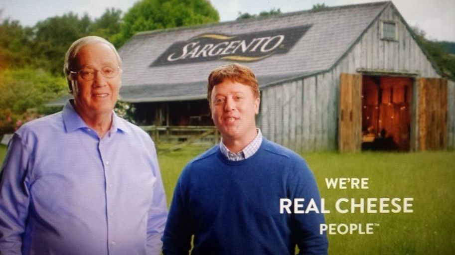 Two guys standing in front of a barn with the tagline "We're REAL CHEESE people"