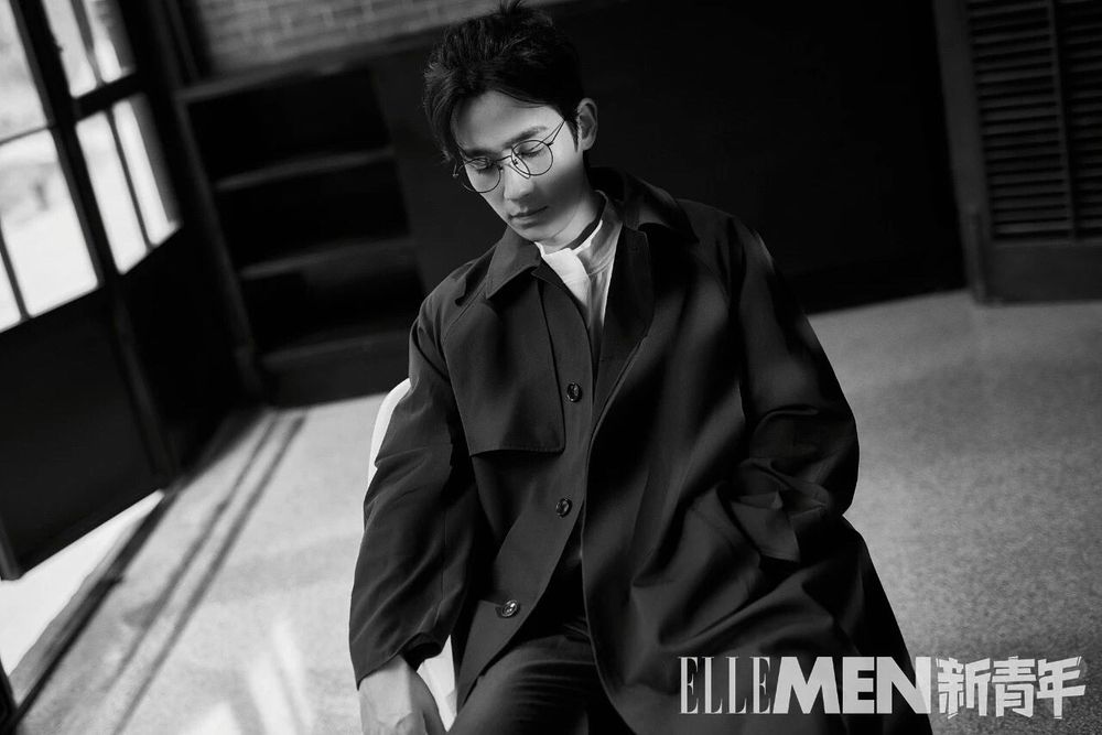 Zhu Yilong wearing a dark trenchcoat and round glasses similar to Shen Wei's