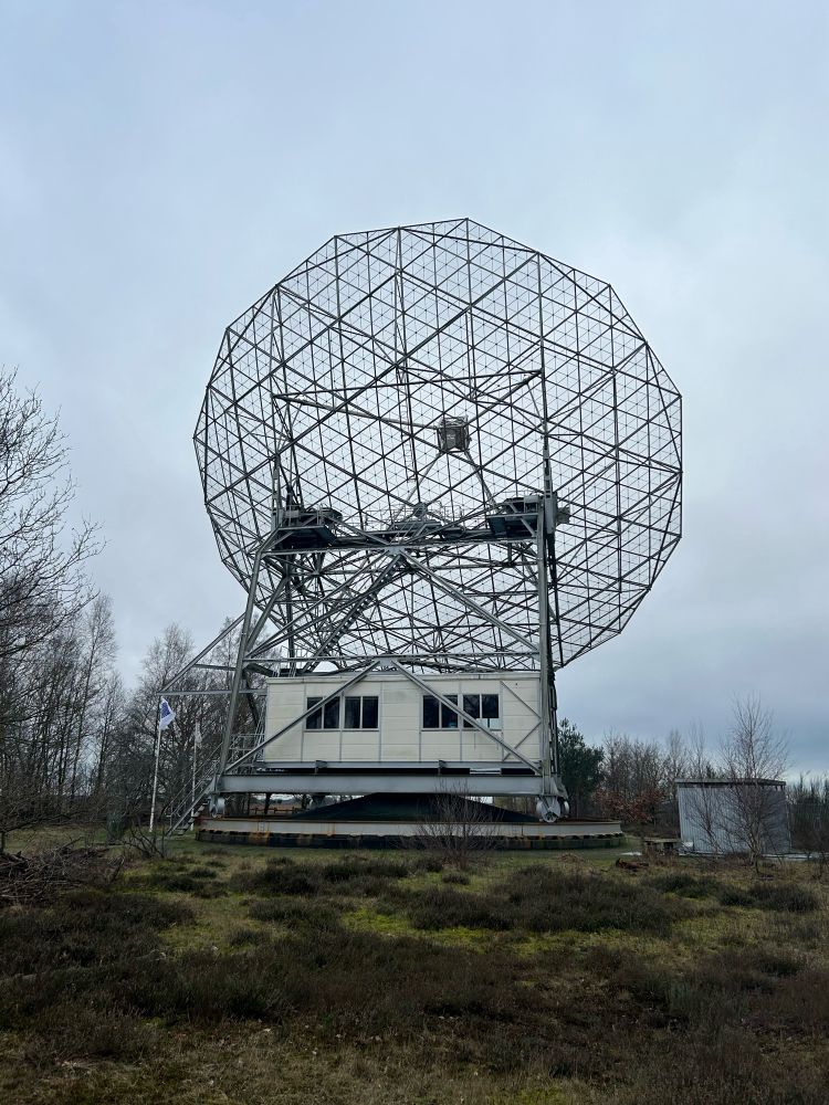 A view of the telescope from the back. You can see through the mesh dish to the receiver. Below the dish is the operator cabin. It is part of the rotating structure of the platform under the dish. Here you can perform point the telescope and record data.
