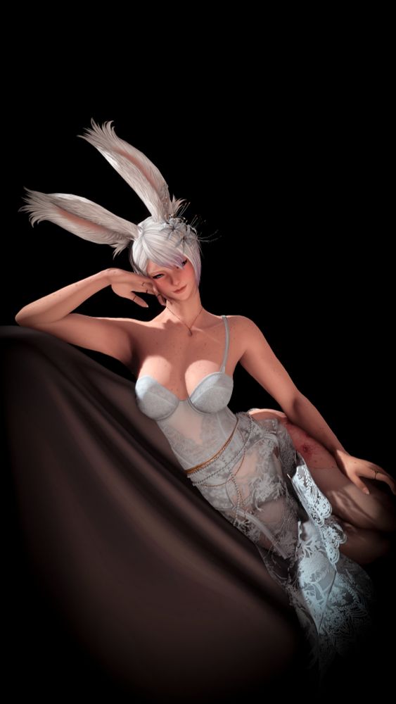 A gpose of a feminine viera, Lys, leaning to the side on top of a draped lounge chair set against a black background. Her right elbow is propped up, her head resting gently on her hand, while her left arm drapes across her  thigh. Her head is tilted, her ears flopping, and she wears a playful smile that she directs toward the camera. She is wearing an ice blue lace dress with a slit that reveals the floral tattoo on her thigh, and a matching spider lily corsage in her hair. 
