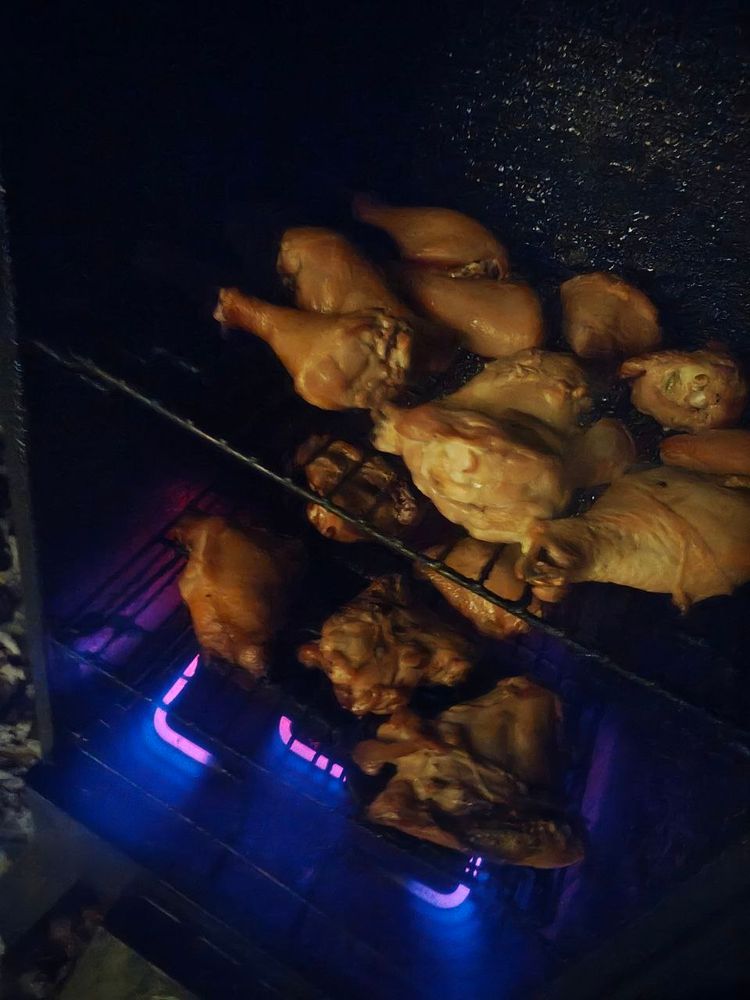 An image of chicken thighs and drumsticks in our electric smoker on two grills 