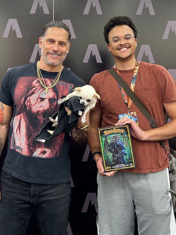 Charles stands next to Joe Manganiello for a picture. Charles holds a signed copy of the HeroQuest expansion, “Joe Manganiello’s Tomb of Perpetual Darkness.” Joe holds his dog, Bubbles, an awkward 12-year old Chihuahua who looks like he’s been old his entire life.