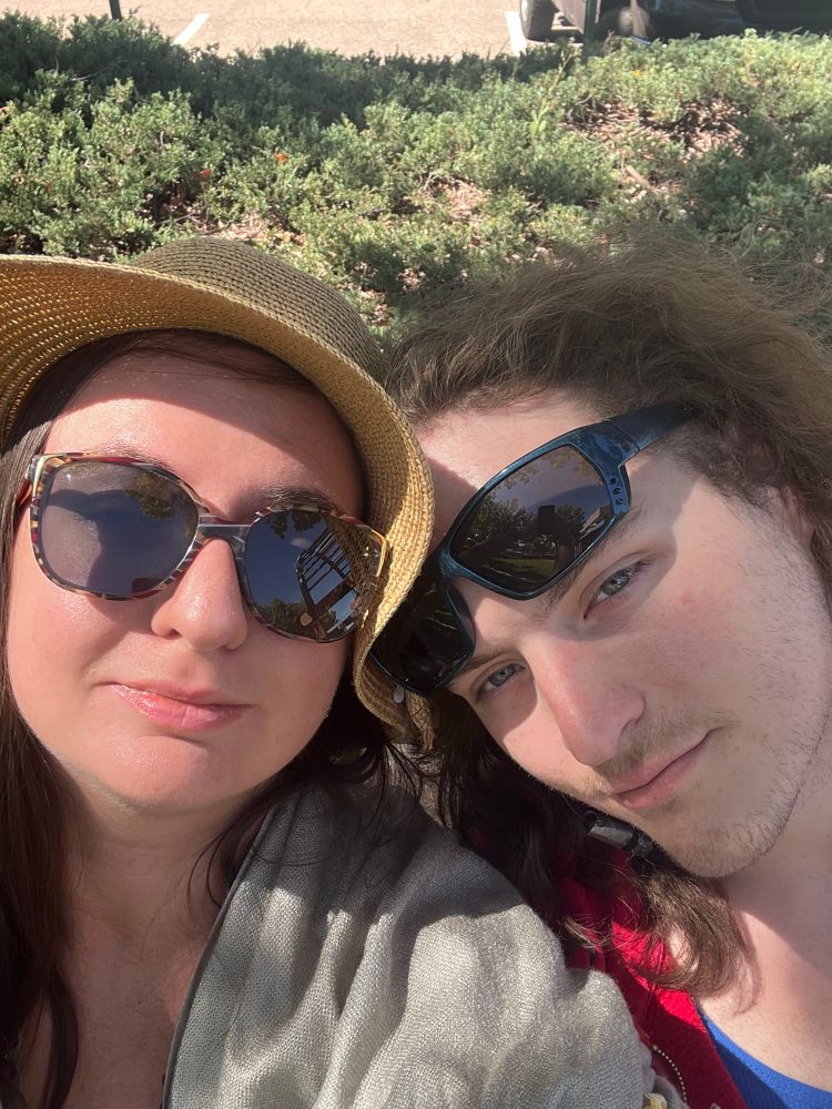 Myself in my sunglasses and hat, with my beautiful partner resting on my shoulder. Both of us are looking at the camera.