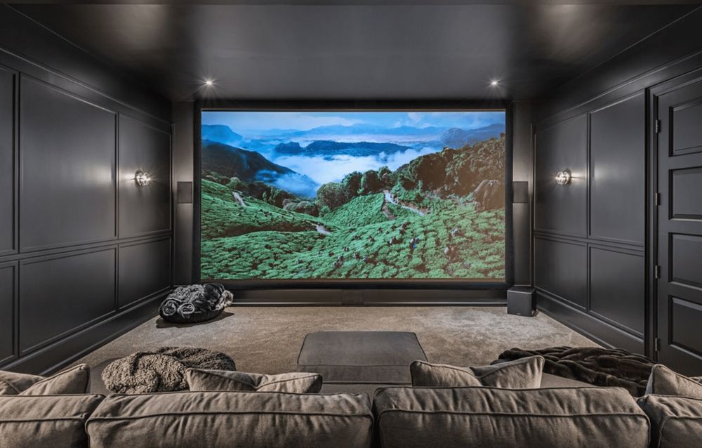 A home movie theater with a wall-sized screen. 