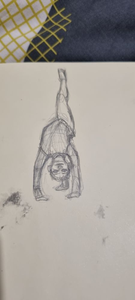 A photo of a sketch of a child in gymnastics clothes, posed upside down, with one leg in the air