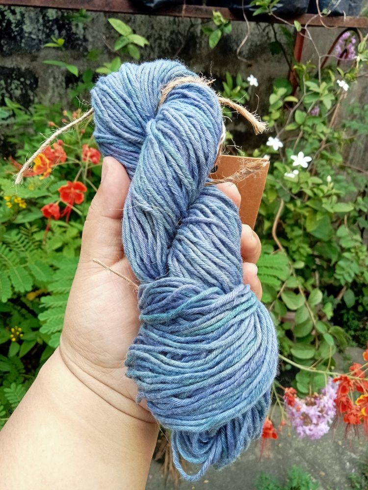 A hank of yarn in this greenish violet ombre hue