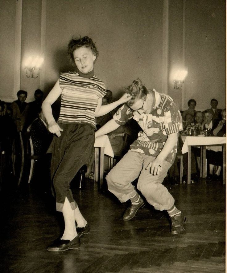 Vintage image of two people dancing wildly.

