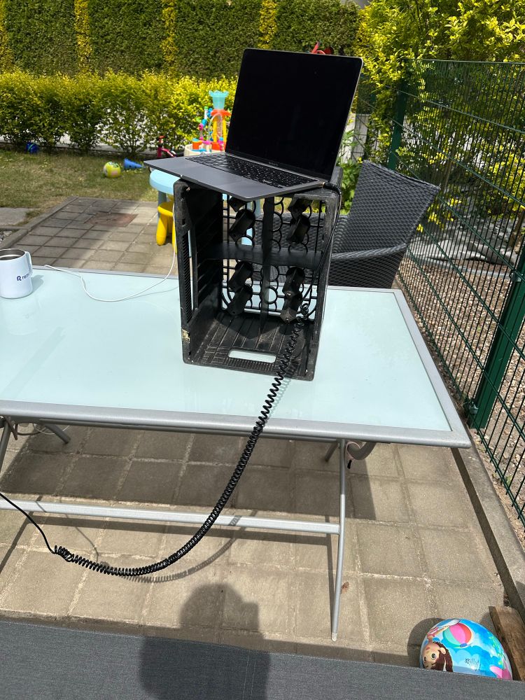 Photo of my laptop in standing desk mode (outdoors on a crate on top of a table, very wobbly)