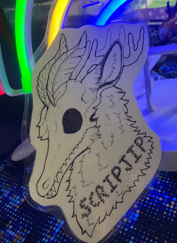 A laminated furry badge of a hybrid creatures named ScripJip done in ink. Character belongs to Scripjip on telegram