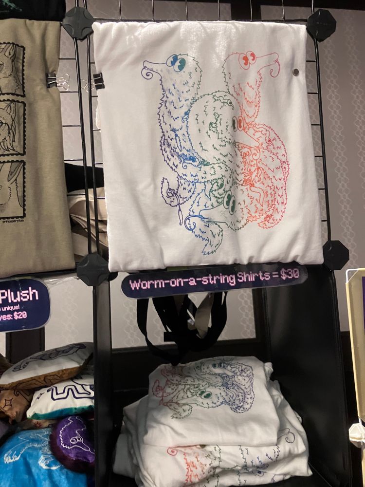 My booth at fureh with a close up of my worm on a string shirts