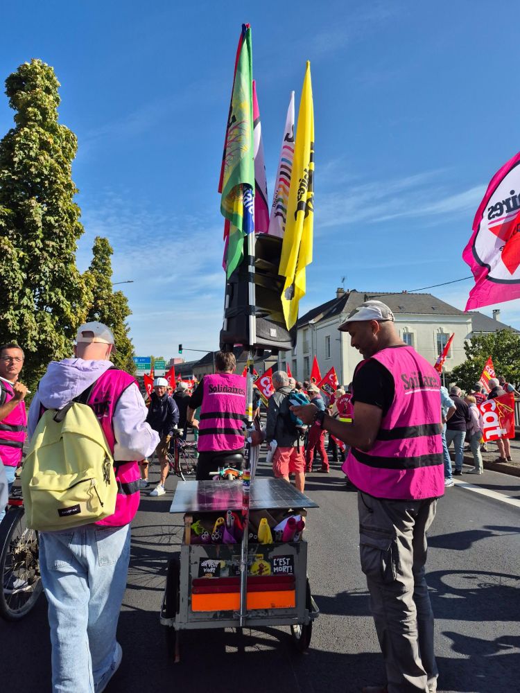 Cortège Solidaires 53 avec le vélo-charette et les chasubles roses.