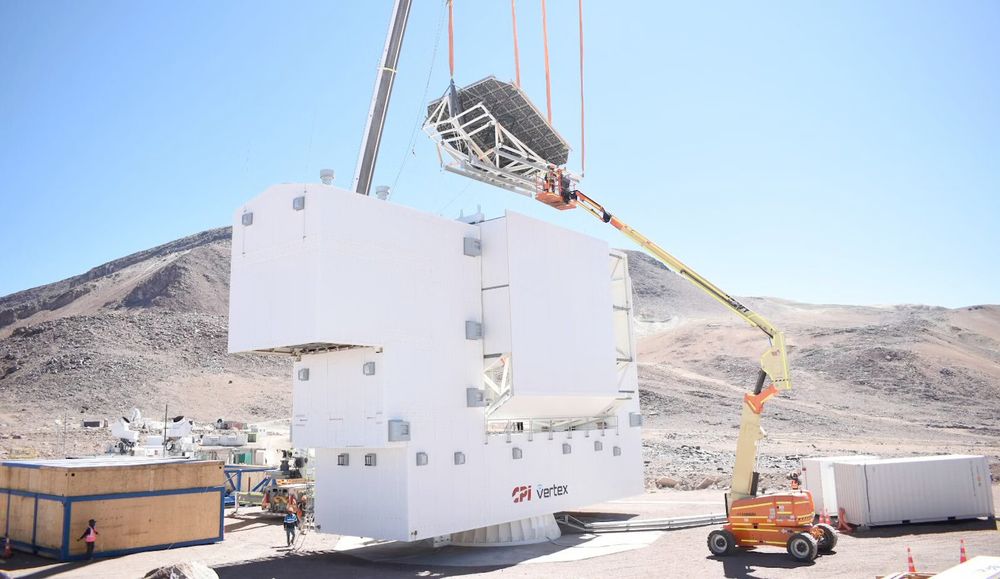 One of the mirrors being lowered by crane inside the white box that constitutes the LAT housing. Behind it is the barren landscape of the Atacama desert
