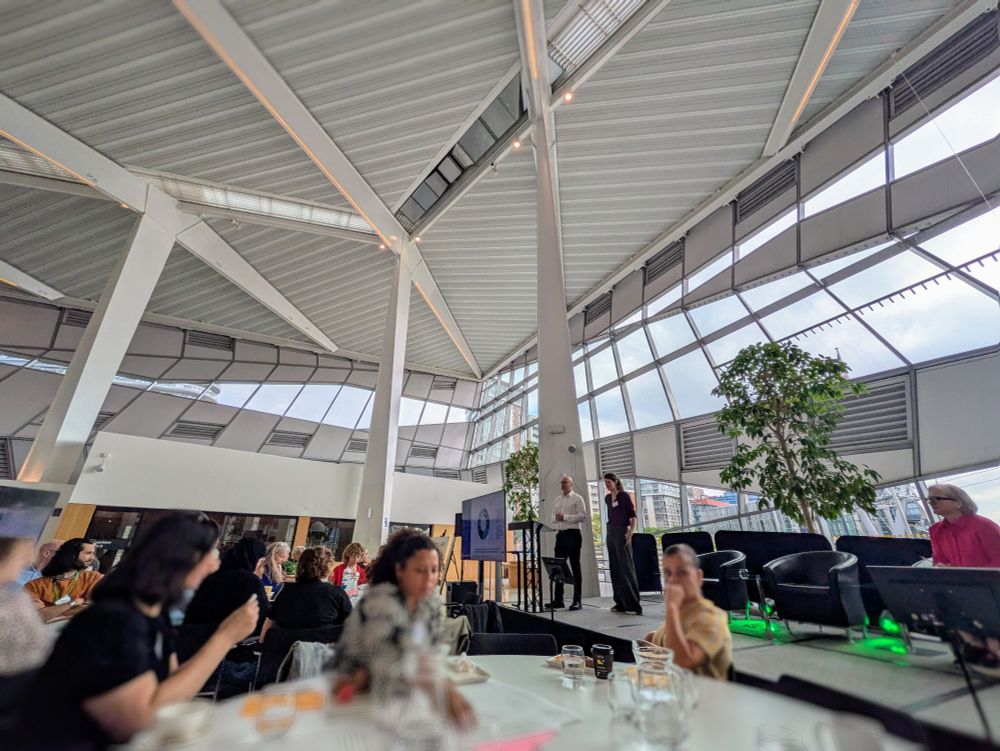 London Loving Room at City Hall, presenters on stage and round tables in front.