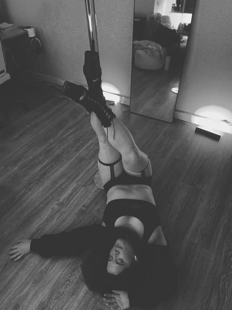 A woman lying on the floor with her legs propped up on a pole