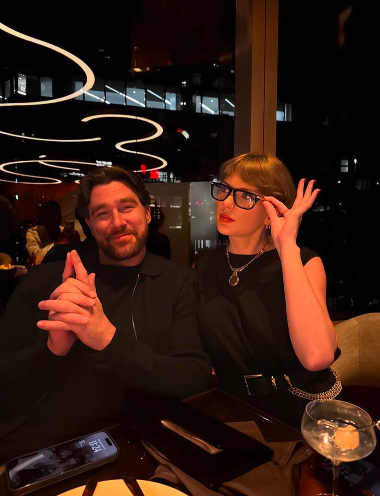 Screenshot from Travis Kelce’s Instagram of a picture of himself and Taylor Swift posing with glasses on. 