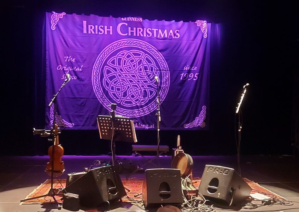 Bühne mit Instrumenten und einer violetten Fahne mit der Schrift "Irish Christmas".