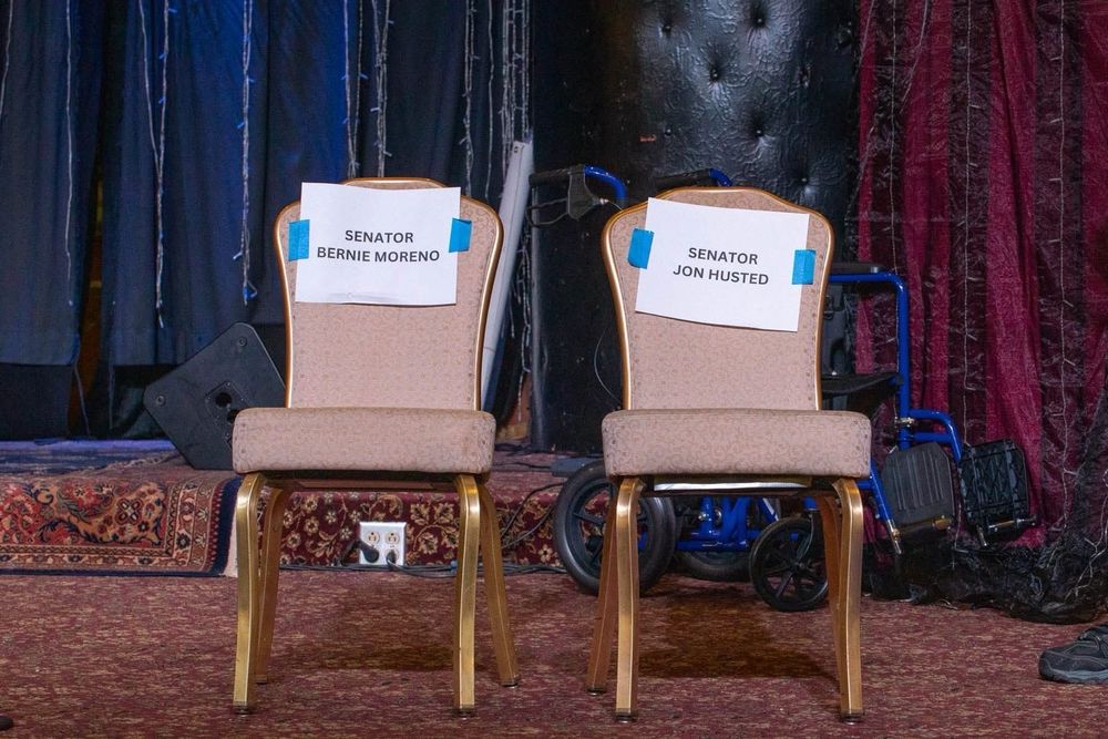 Empty seats with the names Senator Bernie Moreno and Senator Jon Husted taped on them.