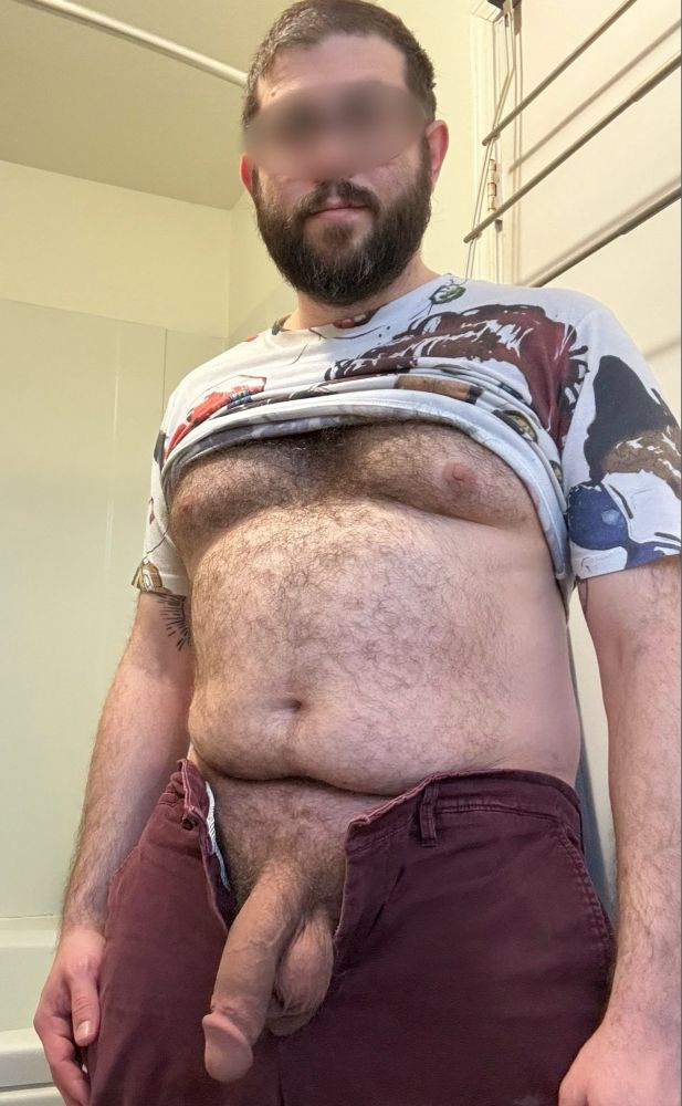 Me standing with my t-shirt pulled up and pants unbuttoned and open. My hairy tits and belly, and big chubby cock are on full display.