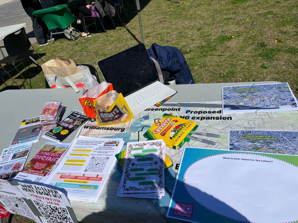 A table with flyers filled with information, markers, candy, a laptop, and a huge map!