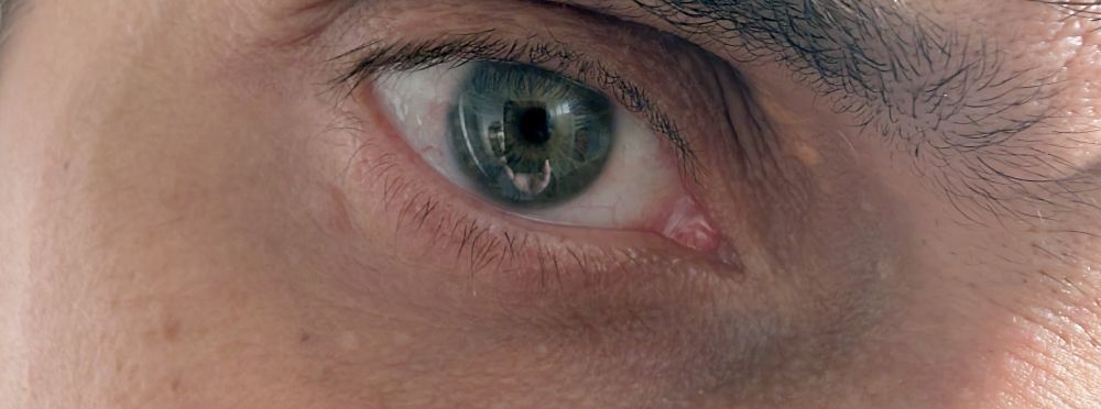 Oeil bleu (ou pas, peut être, il sait pas trop) en gros plan.