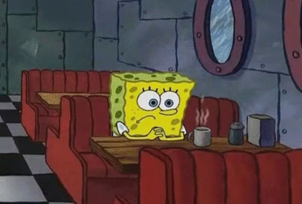 a cartoon of spongebob sitting at a table with a cup of coffee .