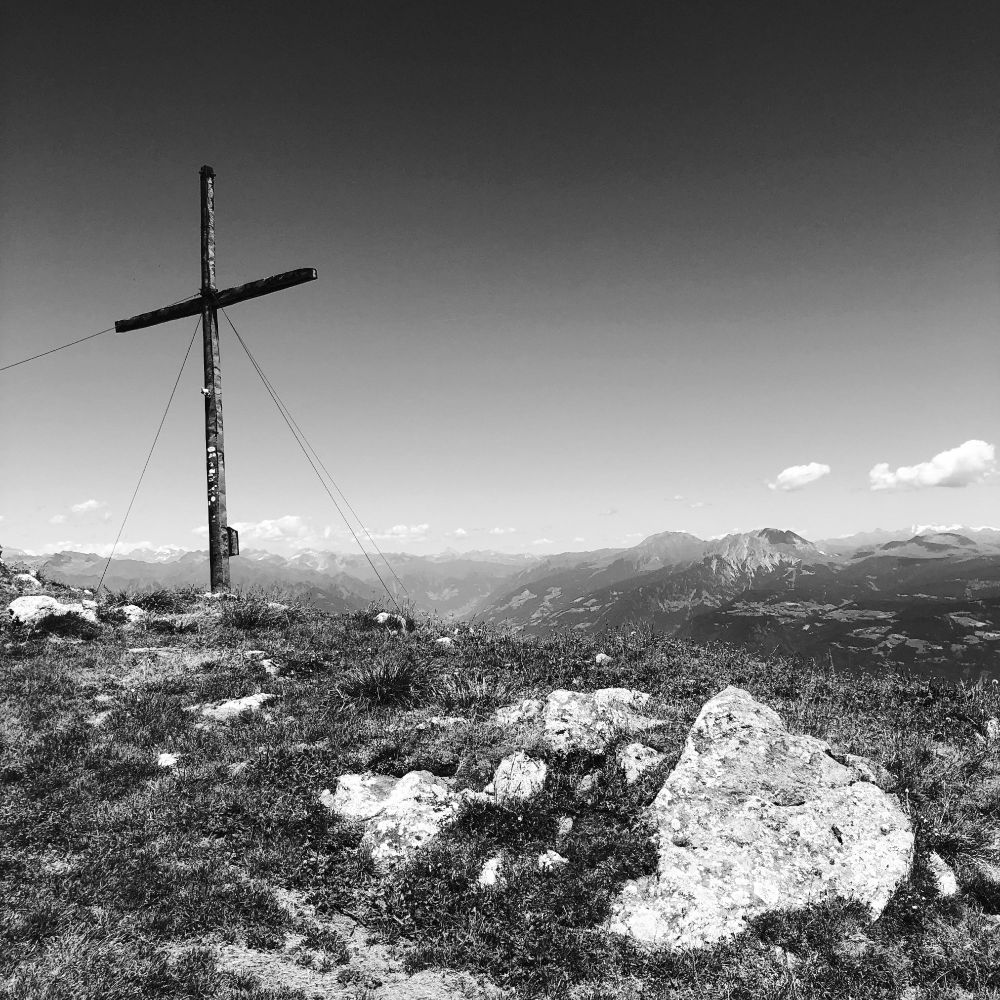 La grande croce sulla cima della montagna e le cime delle montagne dalla parte opposta della valle