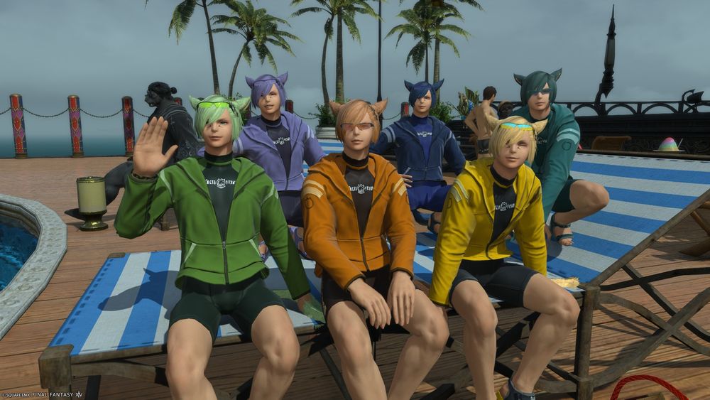 A screenshot of the Grainbow all perched together on a poolside lounge chair. They are wearing color-coded wetsuits and jackets. 