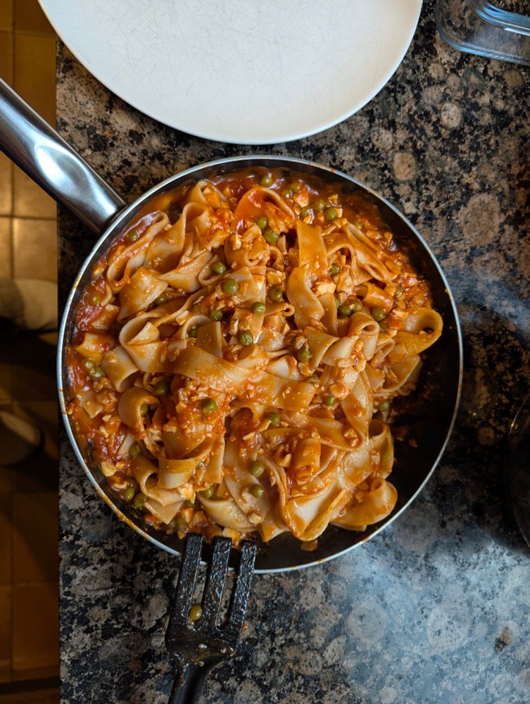 Plato de pasta con tomate, ketchup, guisantes, surimi, bonito y huevo.