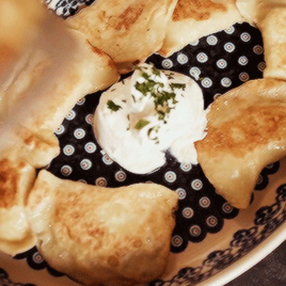 a close up of a plate of food with sour cream and parsley