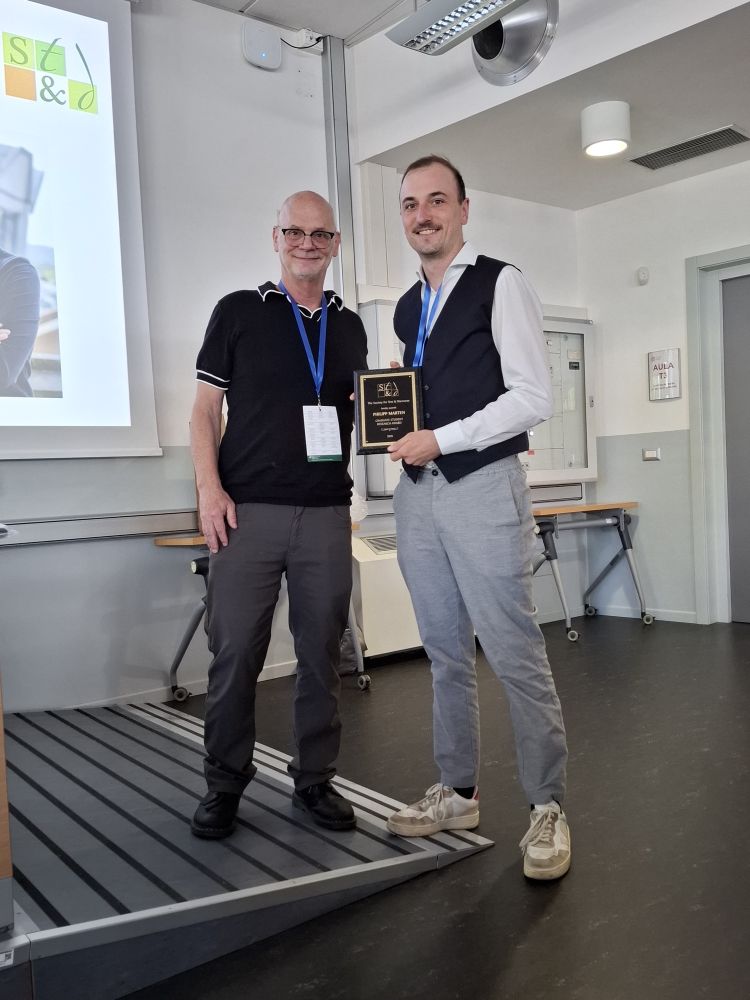 Joe Magliano handing over the Graduate Student Award 2025 from the Society for Text and Discourse to Philipp Marten
