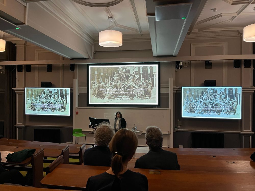A lecture theatre with three screens.