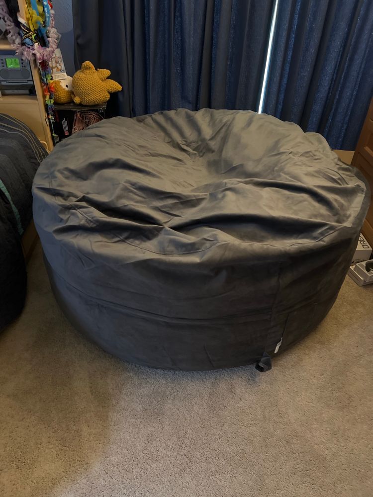 A grey beanbag chair that is taking up most of the floor in front of me.